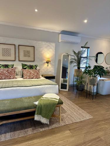 a bedroom with a large bed and a mirror at Pepper Tree Venue & Guesthouse in Bloemfontein