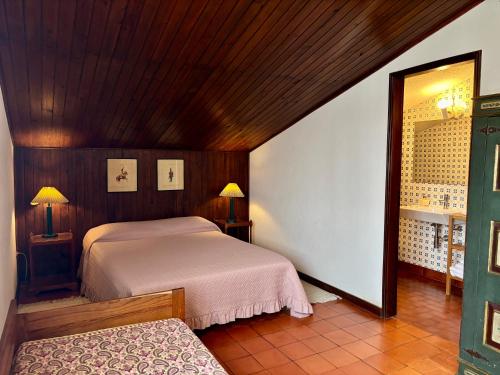 a bedroom with two beds and a mirror at Casa de praia com piscina in Árvore