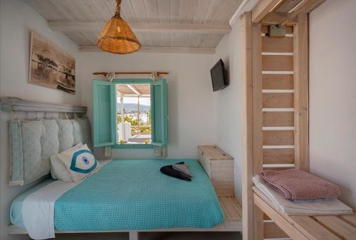 a bedroom with a bed with a window and a ladder at Bougainvillea House in Parikia