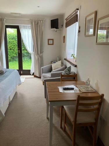 a living room with a bed and a table at Church Farm Hartham in Biddlestone