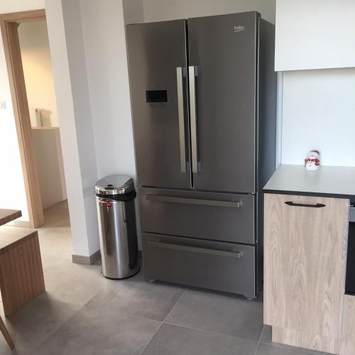 - une cuisine équipée d'un réfrigérateur en acier inoxydable et d'une poubelle dans l'établissement La Clé Des Vignes, à Ribeauvillé