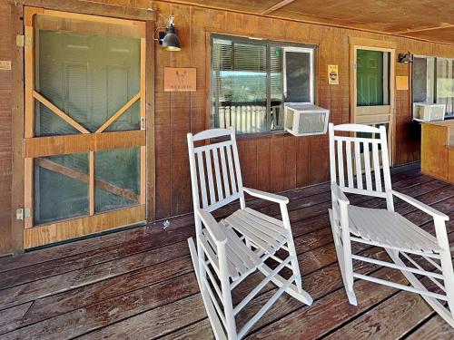 two white rocking chairs sitting on a porch at Mountain View Buck Deer Cabinette in Alto