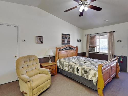 a bedroom with a bed and a chair and a ceiling fan at Mountain View Buck Deer Cabinette in Alto
