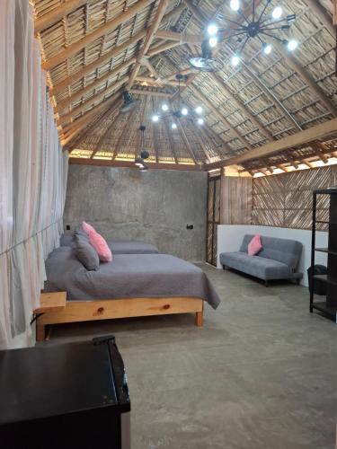 a bedroom with a large bed and a couch at Casa Xolococo in Brisas de Zicatela
