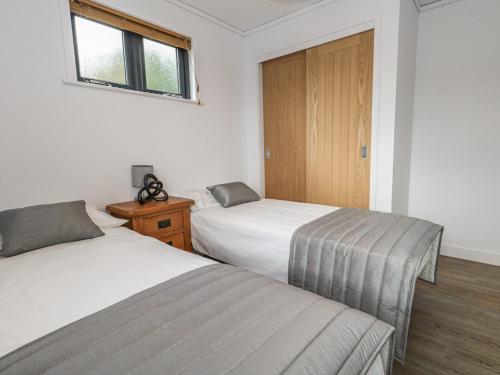 a bedroom with two beds and a wooden door at Grass Roots in Temple Combe