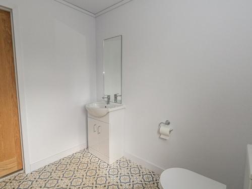 a white bathroom with a sink and a toilet at Grass Roots in Temple Combe