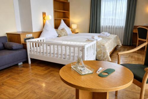 a room with a bed and a table and a couch at Grüner Baum in Bad Staffelstein