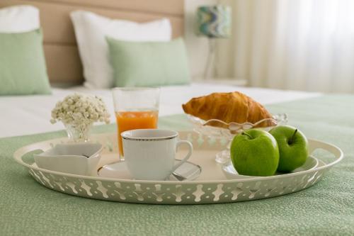 un vassoio con un piatto di cibo e frutta su un letto di Simon Guest Apartments a Porto