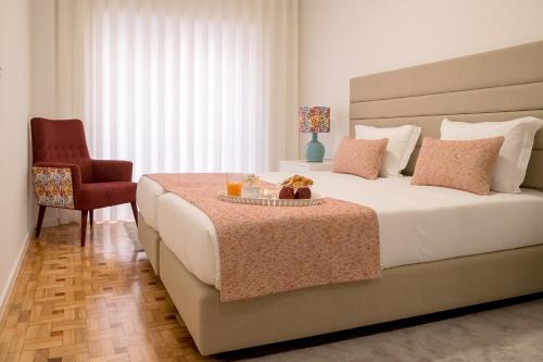 a bedroom with a large bed and a chair at Simon Guest Apartments in Porto