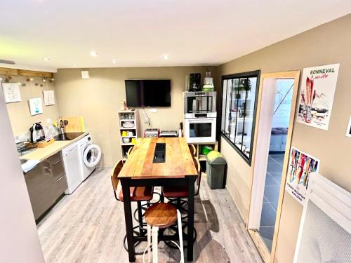a kitchen with a table and chairs in a room at La Skibelle Orelle-ValThorens- Sauna & bain nordique in Orelle