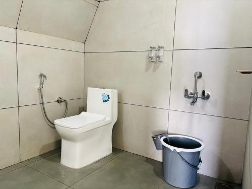 a bathroom with a toilet and a trash can at Wilmora in Ramakkalmedu