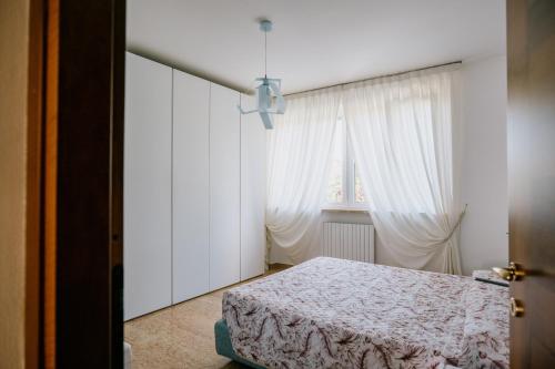 a bedroom with a bed and a window at Riva Serena - Appartamento Oasi in Castelnuovo del Garda