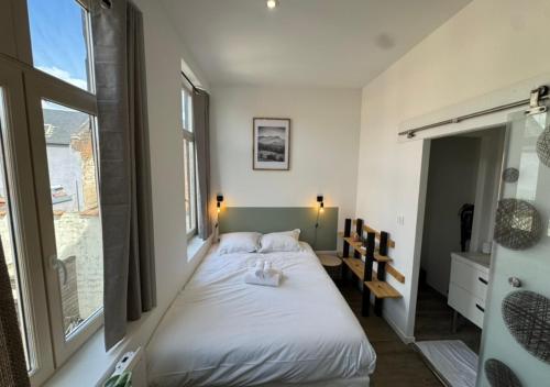 a bedroom with a white bed and a window at Studio cosy Amiens in Amiens