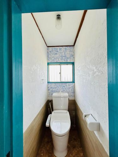 a bathroom with a toilet and a window at K'sVILLAGE 平砂浦ハウスＳ in Tateyama