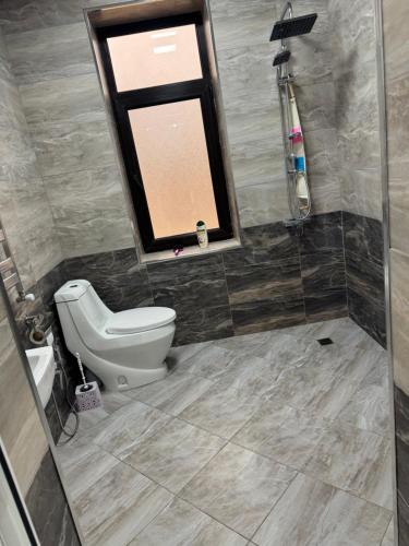 a bathroom with a toilet and a window at house for daily rent in Laza