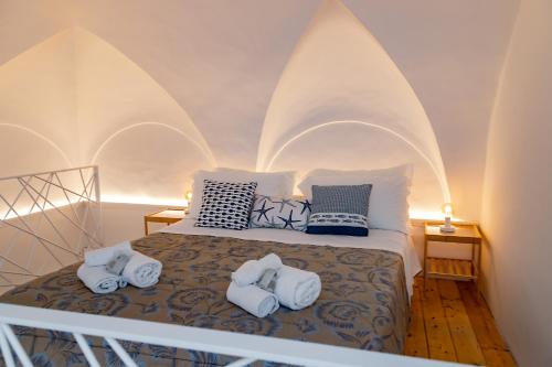 a bedroom with a bed with three towels on it at Il borgo di Ulisse in Gaeta