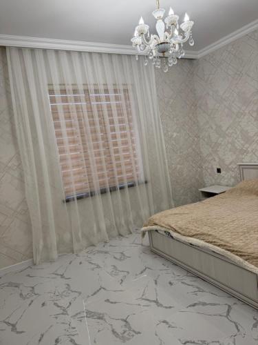 a bedroom with a bed and a chandelier at house for daily rent in Laza