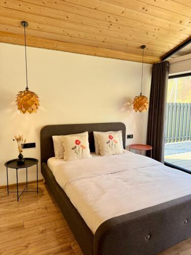 a bedroom with a large bed with two pillows at Boiko house - котеджі з чаном-джакузі та басейном in Slavske