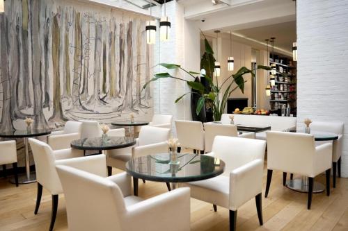 a dining room with tables and white chairs at Hôtel Le A - Champs-Elysées in Paris