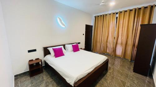 a bedroom with a bed with two pink pillows at seaside residence negombo in Negombo