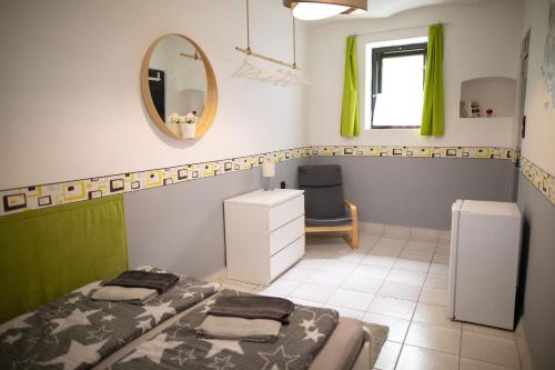 a bedroom with two beds and a mirror and a chair at Pajtás Vendégház in Örvényes