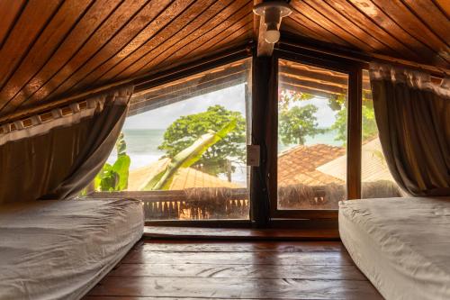 a room with a window with a view of the ocean at Beach House NATUREZA self check-in in Itacaré