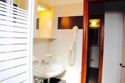 a bathroom with a sink and a phone in it at Depandance President in Cesenatico