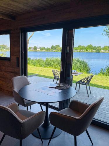 a patio with a table and chairs and a view of the water at Friesensee Camping und Ferienpark in Wittmund