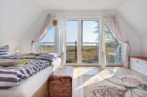 a bedroom with a bed and a large window at Rügenblick in Klausdorf Mecklenburg Vorpommern