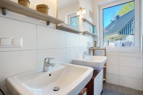 a bathroom with two sinks and a window at Rügenblick in Klausdorf Mecklenburg Vorpommern