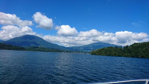 a boat on a lake with mountains in the background at Tabataya in Myoko