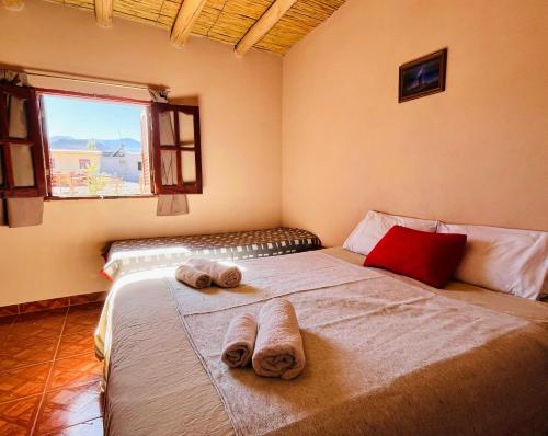 a bedroom with a large bed with towels on it at EL AMANECER hospedaje y excursiones in El Peñón