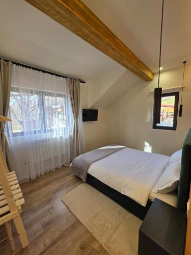 a bedroom with a large bed and a window at CabanaFriendly in Râşnov
