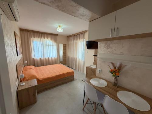 a bedroom with a bed and a table and chairs at Eleonor Guest House in Byala