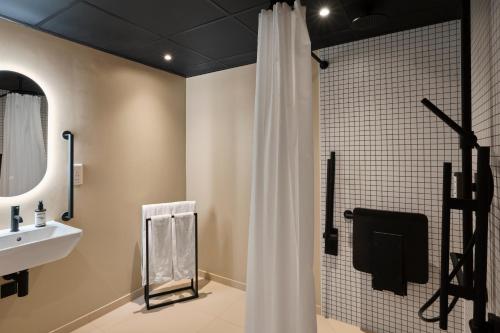 a bathroom with a white shower curtain and a sink at Good Hotel London in London