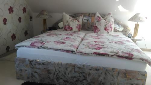 a bed with a floral bedspread and pillows on it at Haus Göhrenz in Markranstädt