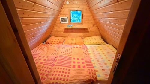 a bedroom with a bed in a wooden cabin at Chata Sekule in Sekule