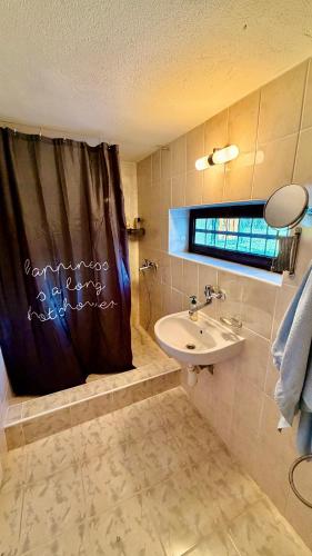 a bathroom with a sink and a shower curtain at Chata Sekule in Sekule