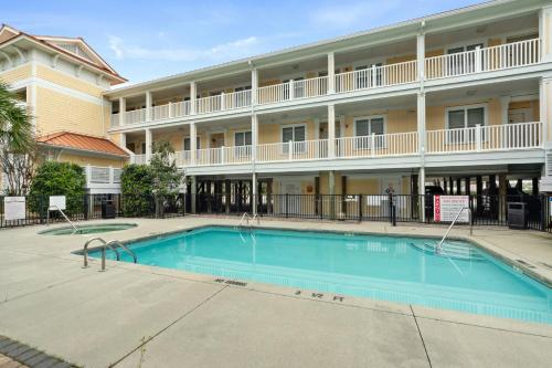 a swimming pool in front of a hotel with a building at Dreamer by Oak Island Accommodations in Oak Island