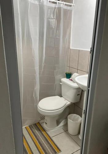 a bathroom with a toilet and a sink at #1 Jardín de las cabanas in San Pedro Carchá