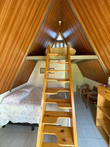 a loft bed in a room with a ladder at #1 Jardín de las cabanas in San Pedro Carchá