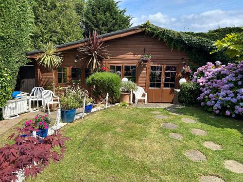 a small wooden house with a garden in front of it at Silverleigh Spa LTD in Fawkham
