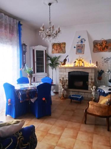 a living room with blue chairs and a fireplace at Villa Rosa in Acqualagna