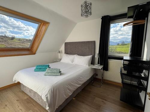 a bedroom with a bed with two pillows on it at Wallace Lodge in Crieff