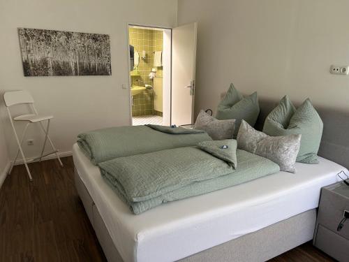 a bed with green blankets and pillows on it at Ferienwohnung Calluna in Buchholz in der Nordheide