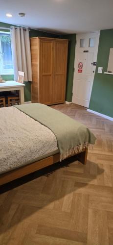 a bedroom with a bed and a table and a door at furnace halls in Taffs Well