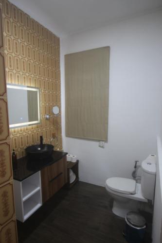 a bathroom with a toilet and a sink and a mirror at Castaway Lodge in Pointe Au Sel 
