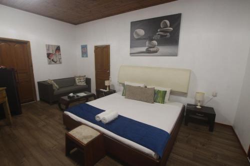 a bedroom with a large bed and a couch at Castaway Lodge in Pointe Au Sel 