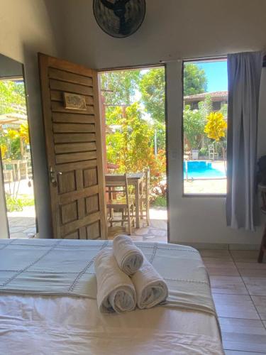 a bedroom with a bed with two towels on it at Hostel do Ceu in Pipa