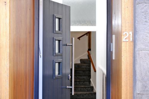 a door leading into a hallway with stairs at Ben Shea Smart Home in Dufftown